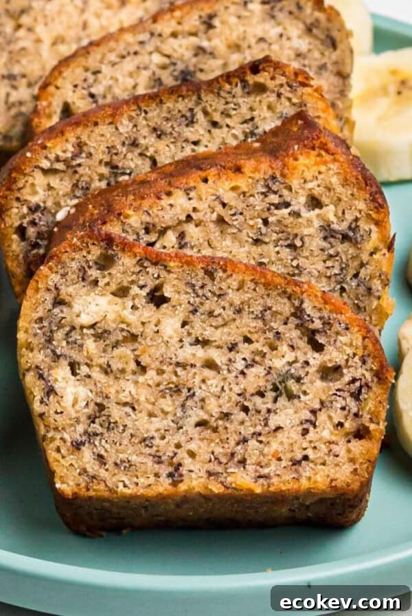 Air fryer banana bread on a light green plate with slices of bananas.