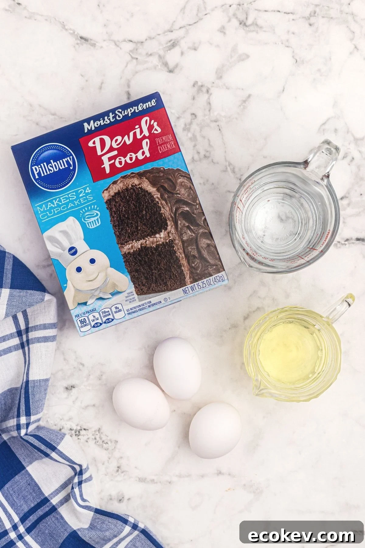 Box cake mix with oil, eggs, and water needed to make cake in air fryer on a white marble board