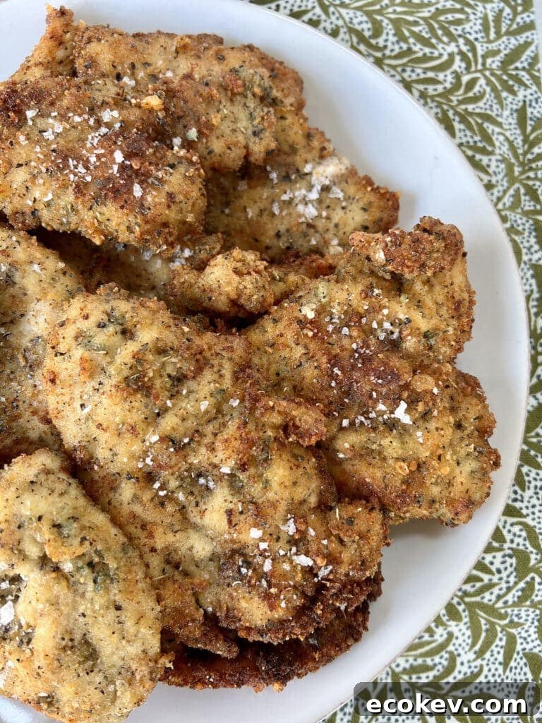 Italian Chicken Cutlets on a white plate on towel.