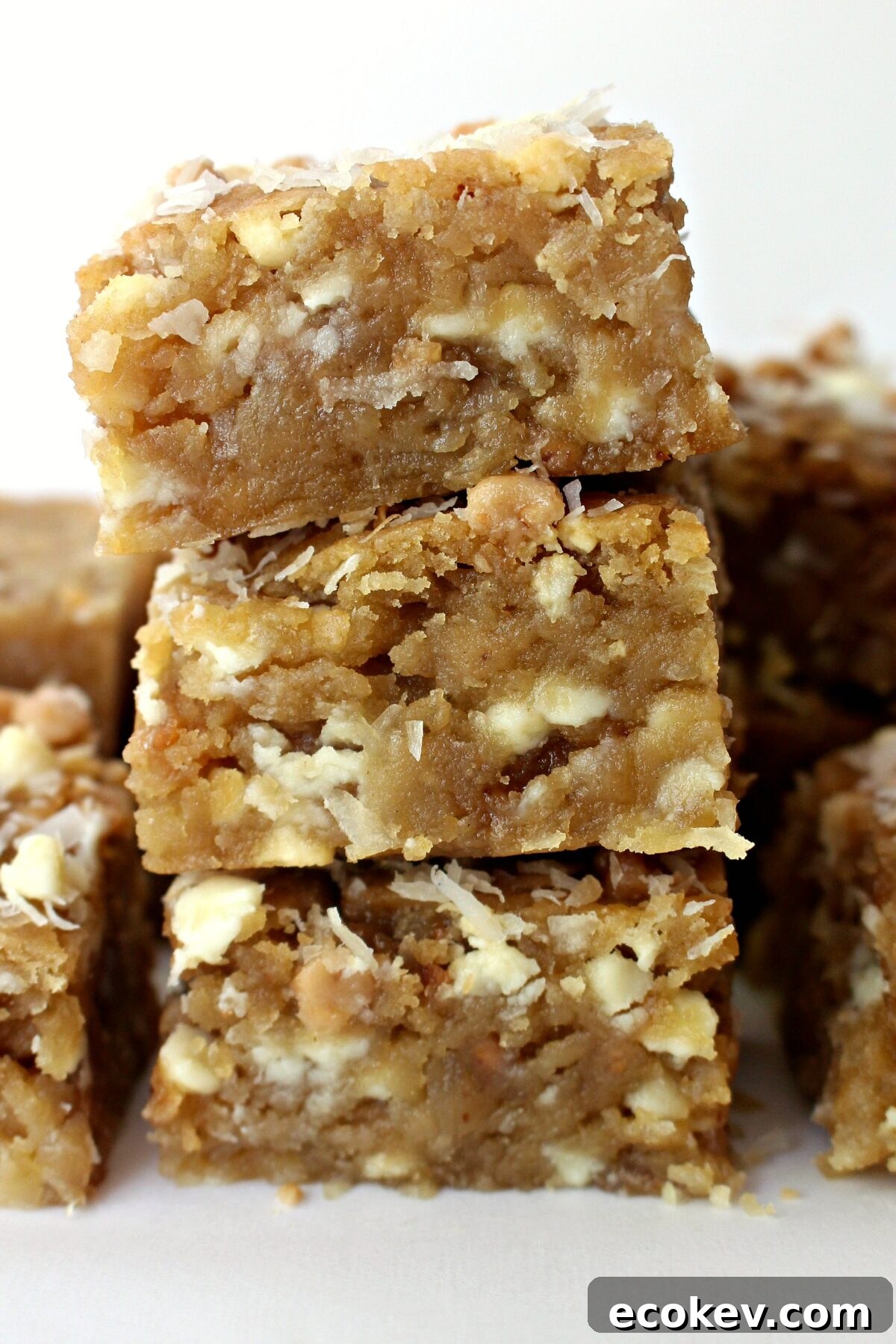 Stack of three Coconut Blondies showing thick, soft interior.