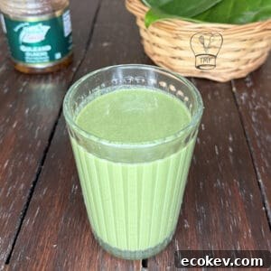 Glass of refreshing green betel leaf drink, traditional paan shot beverage.