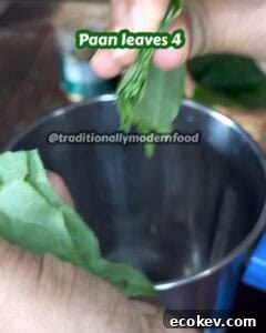 Fresh betel leaves being prepared for a traditional paan shot.