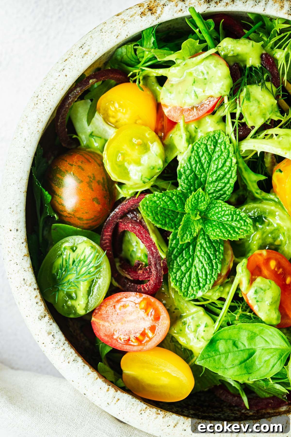 A close-up of a simple salad will avocado green goddess salad dressing.