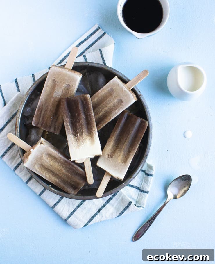 Cake pan of popsicles next to a small pitcher of cream and coffee