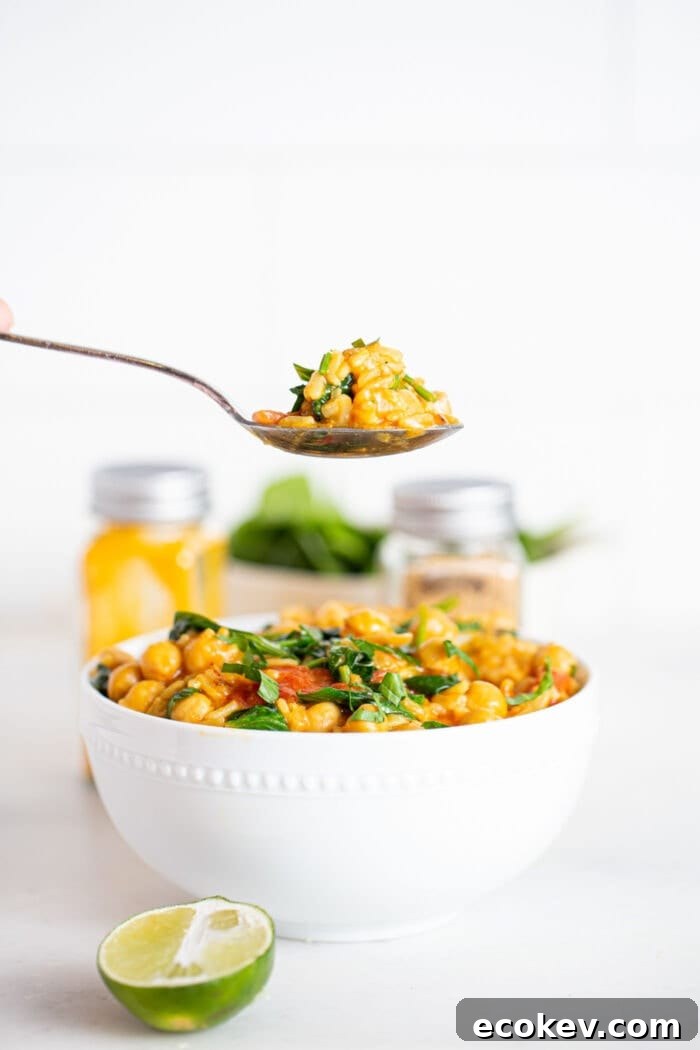 Taking a spoonful of rice, chickpea and spinach stew.