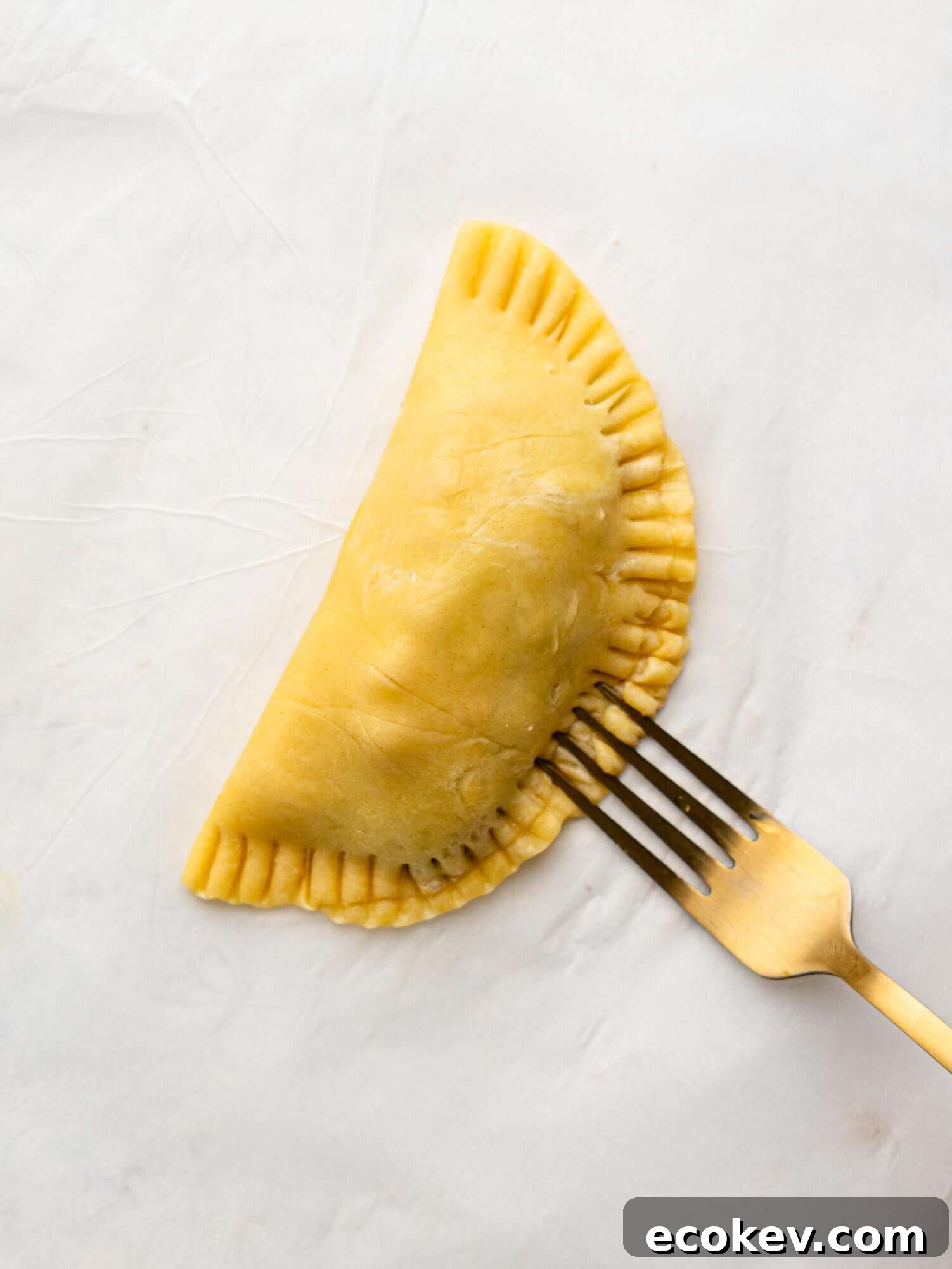 Crimping an empanada with a fork.