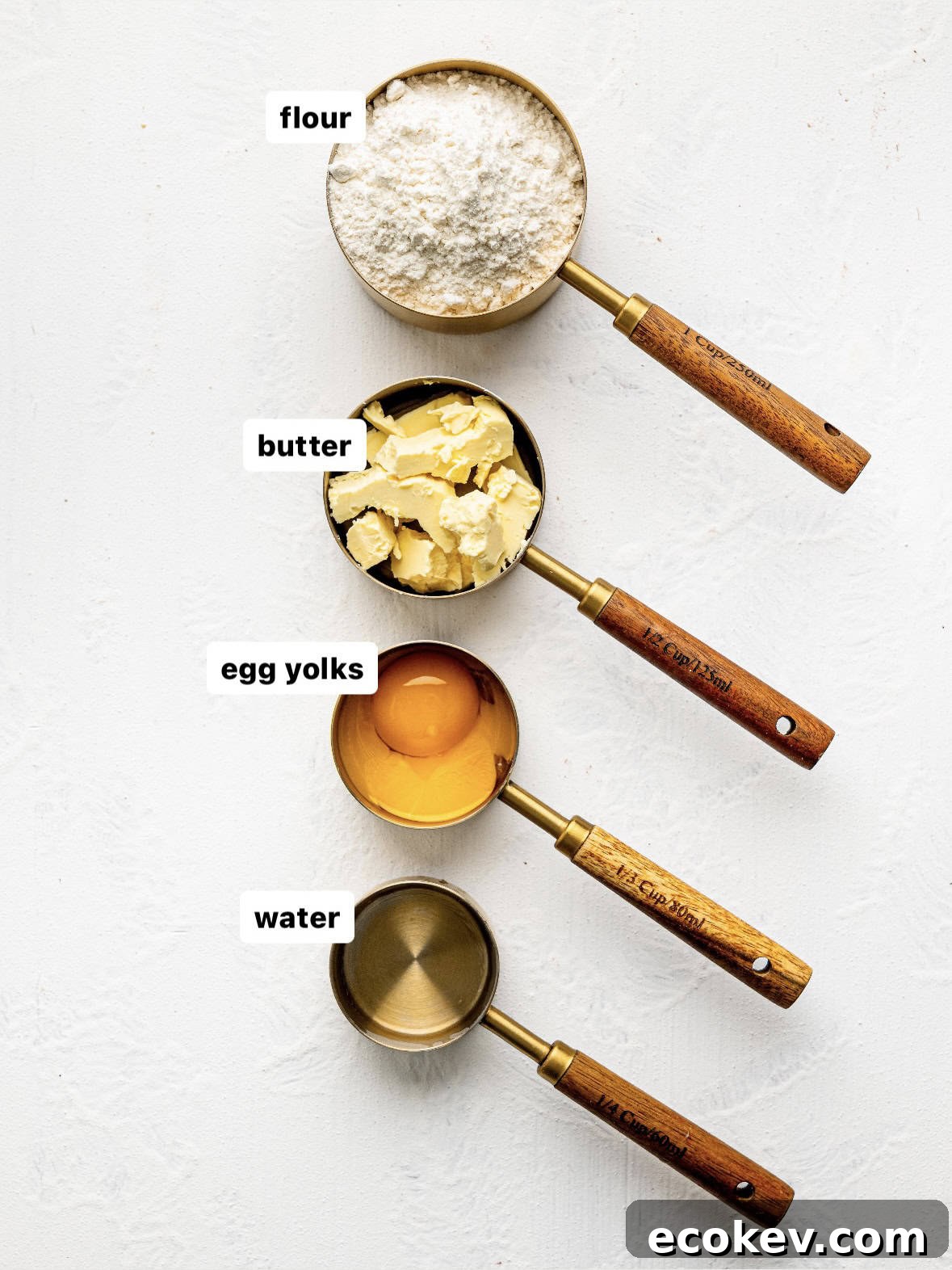 Easy empanada dough ingredients in measuring cups on a counter.