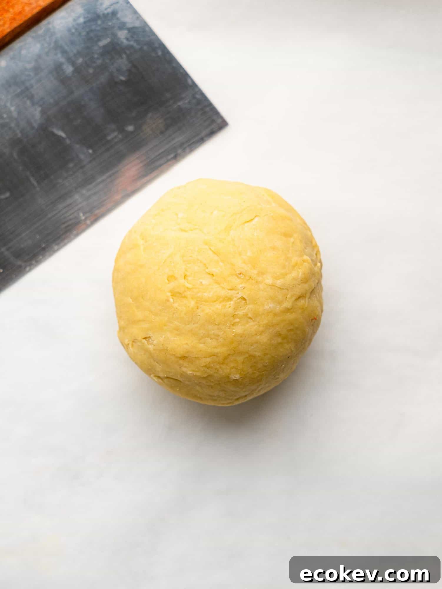 Easy empanada dough ball on a sheet of parchment paper.