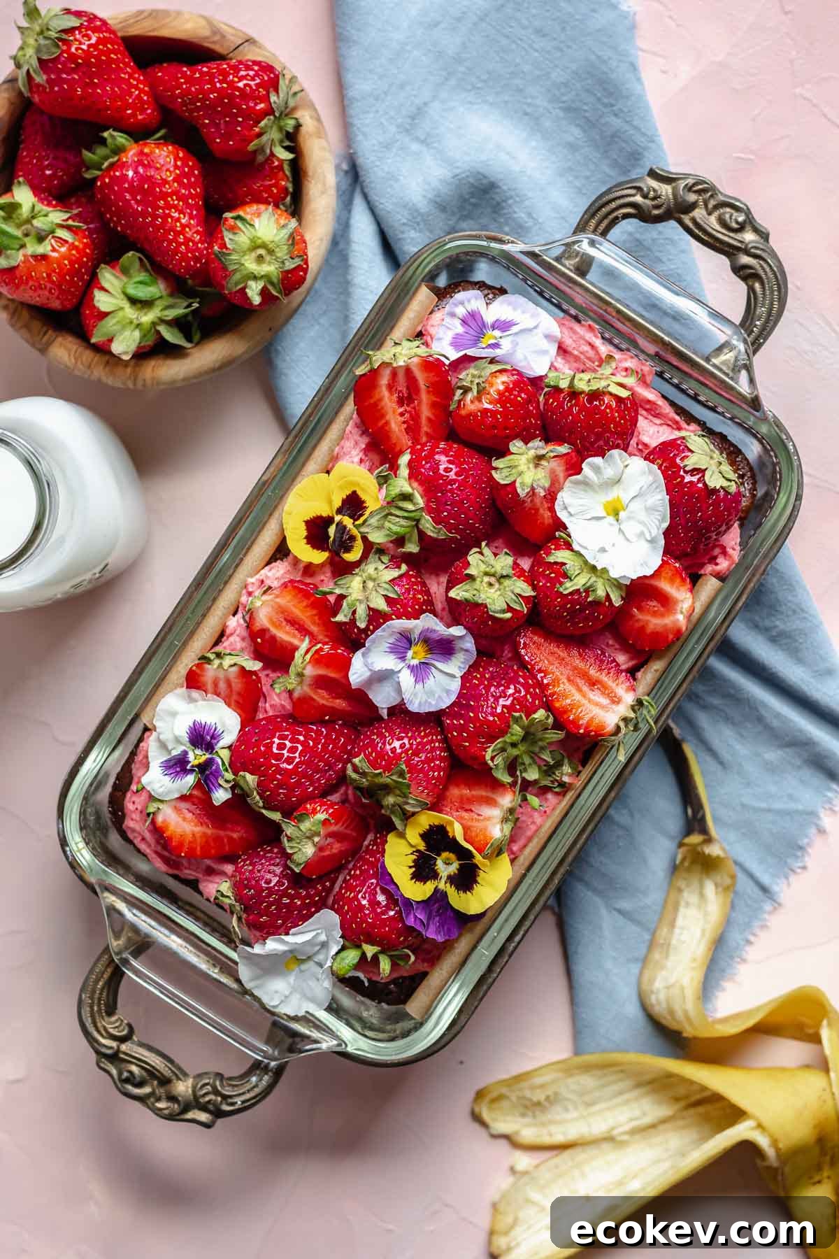 Finished strawberry banana cake with strawberries on top.