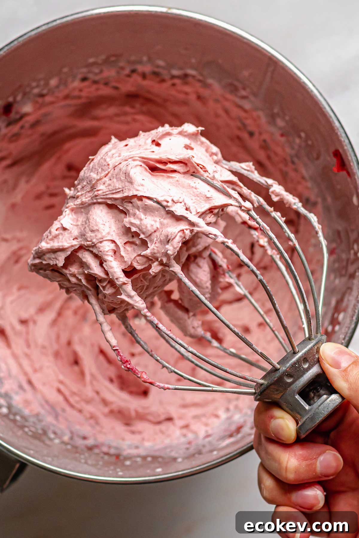 Freeze dried strawberry frosting on a whisk.