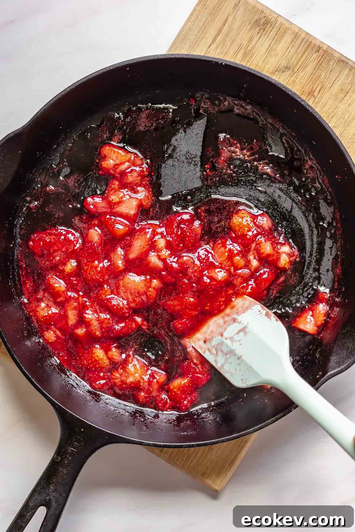 Strawberries cooking down in a pan.