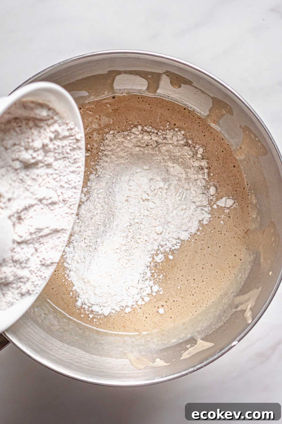 Flour being added to wet ingredients.