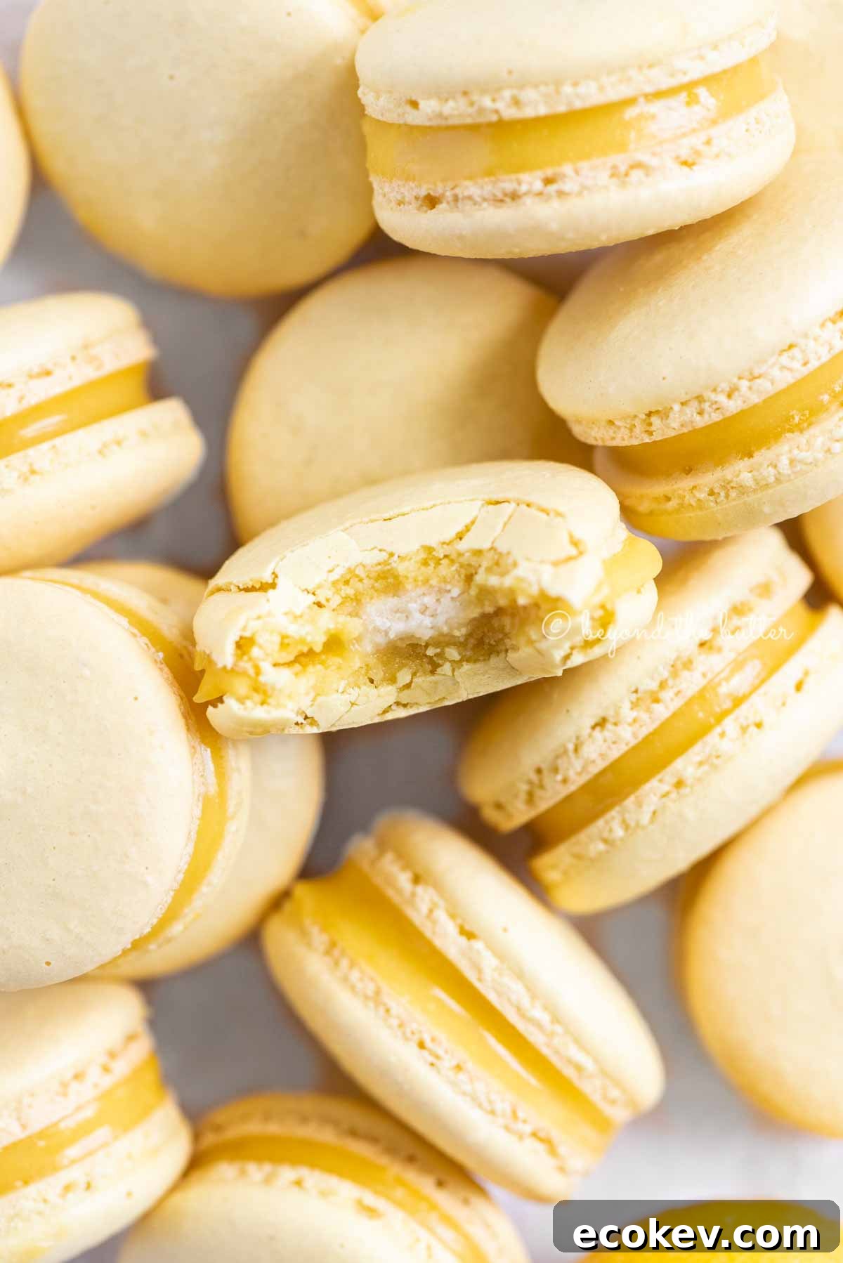 Randomly placed lemon macarons with a bite taken out of the center macaron | All Images © Beyond the Butter™