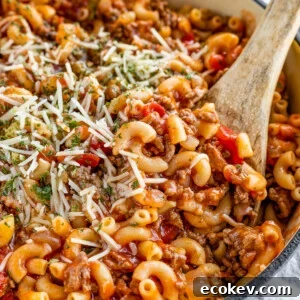 American Goulash Being Mixed in a Pot with a Wooden Spoon