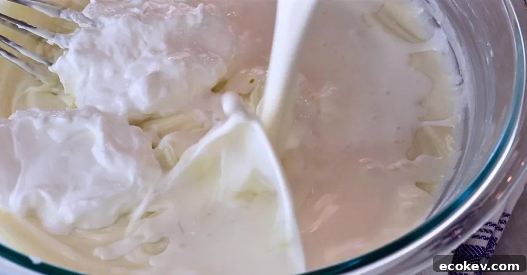 adding sour cream and heavy cream to cream cheese mixture