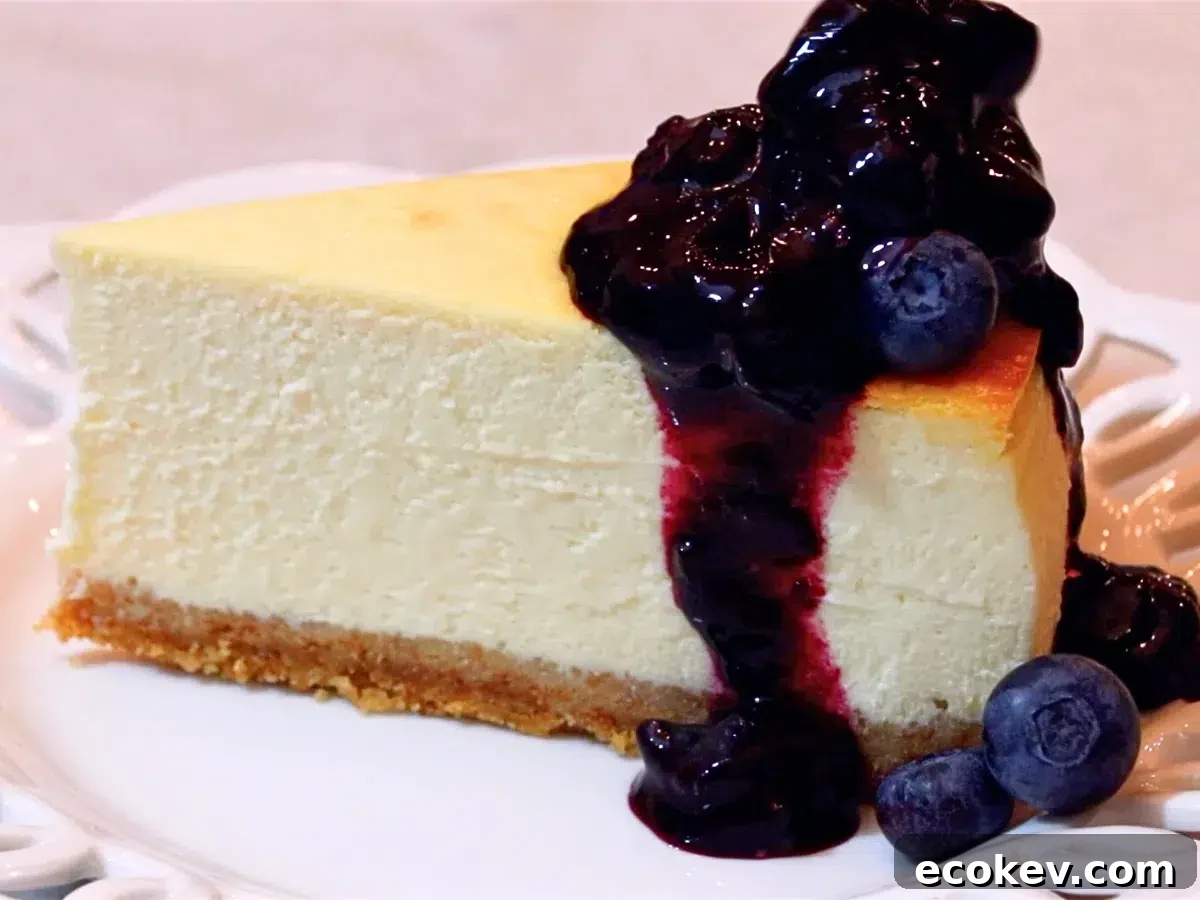 a slice of baked cheesecake with homemade blueberry sauce and fresh blueberries on top