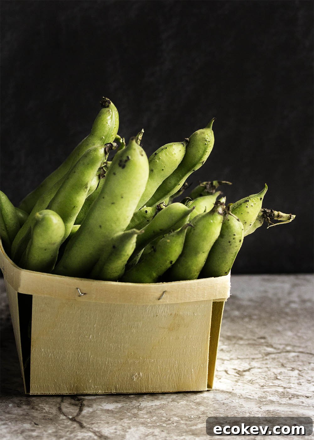 Close-up of fresh fava beans with shaved parmesan on top.