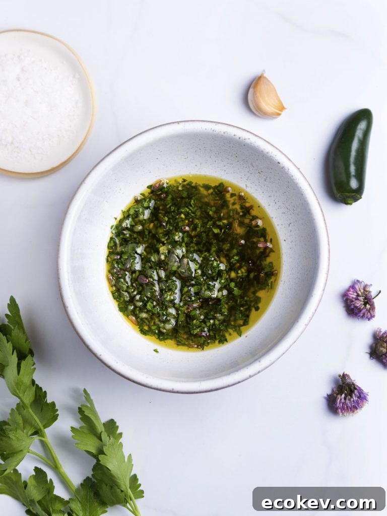 herb oil in a white bowl made with fresh herbs, pepper and garlic
