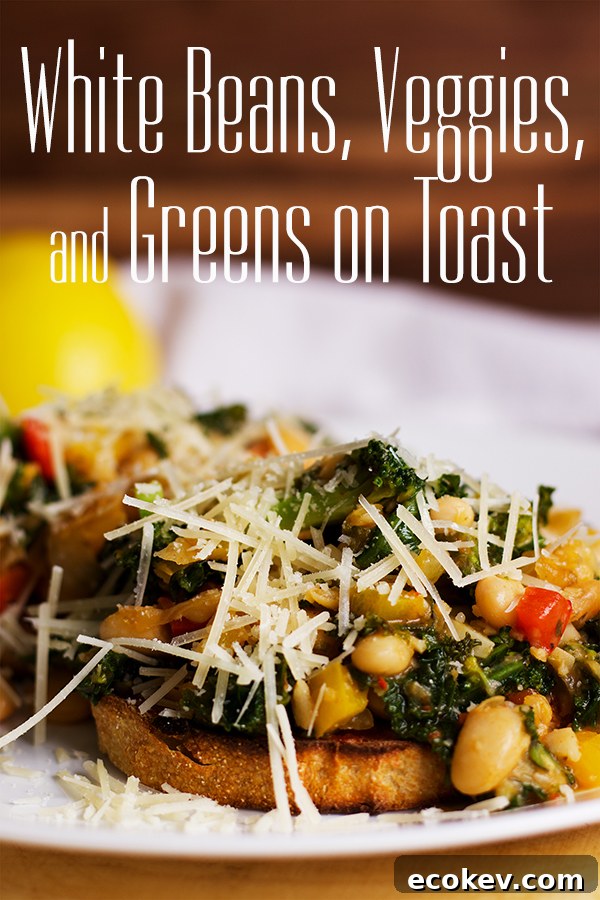 A plate with two slices of toast topped with white beans, veggies and greens.