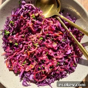 A bowl of colorful red cabbage coleslaw garnished with parsley.