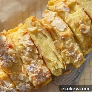 A sliced almond-topped pastry dusted with powdered sugar.