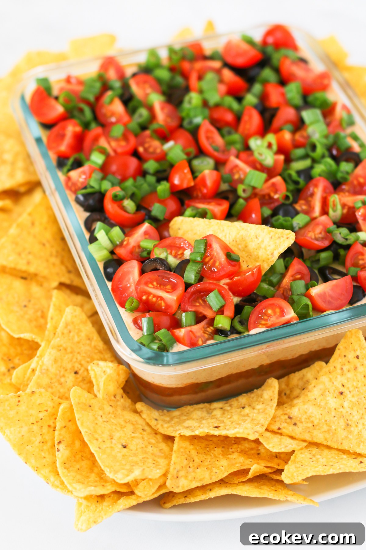 Vegan 7 Layer Bean Dip. Layers of beans, guacamole, creamy taco sauce, salsa and all of the vibrant Mexican flavors.