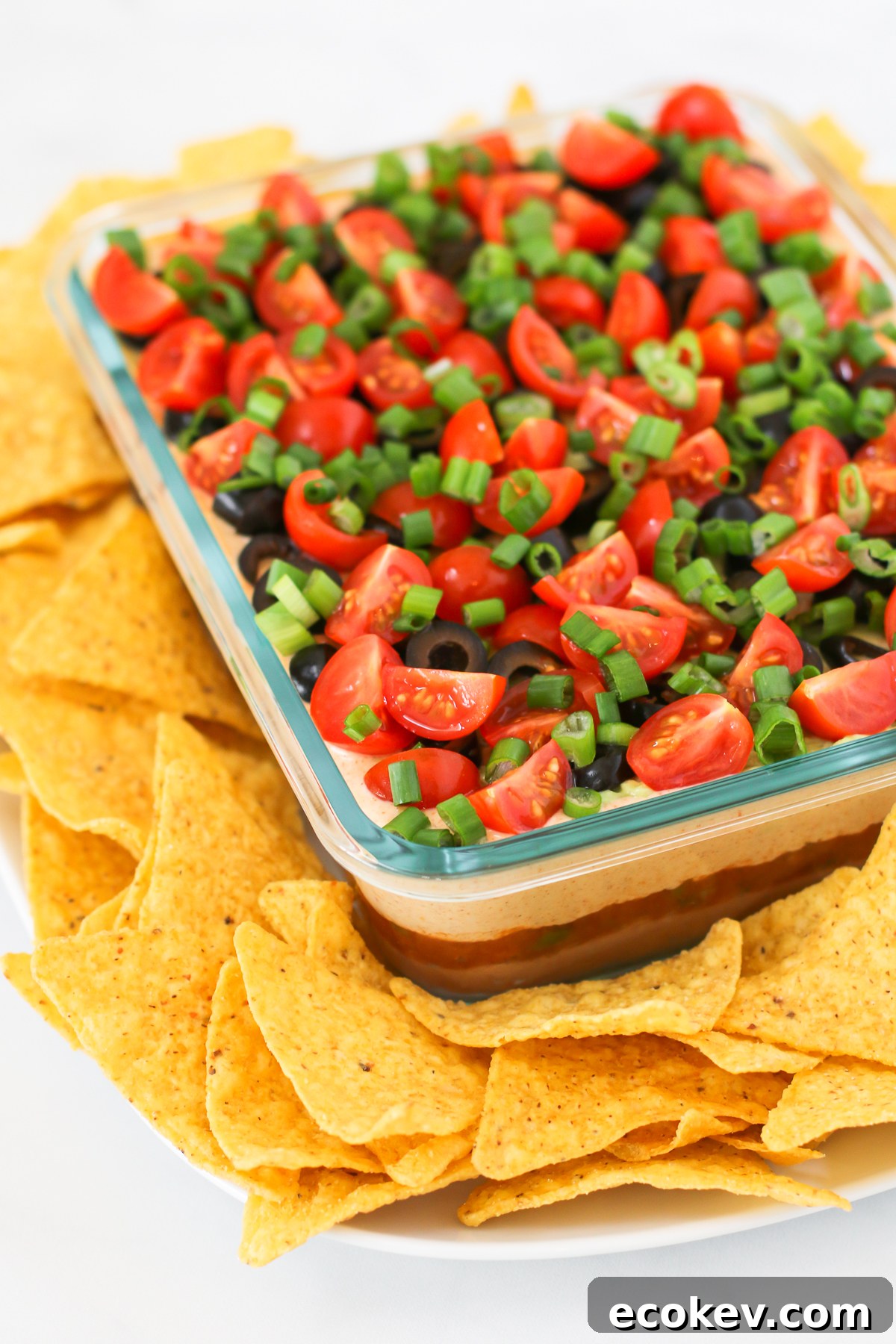 Vegan 7 Layer Bean Dip. Layers of beans, guacamole, creamy taco sauce, salsa and all of the vibrant Mexican flavors.