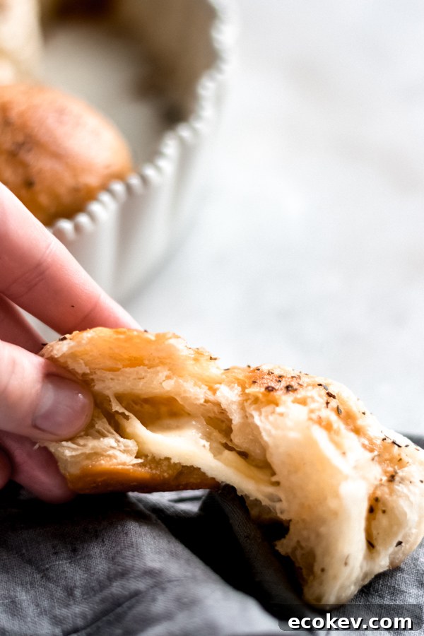 Pulling apart a cheesy garlic herb pull apart roll.