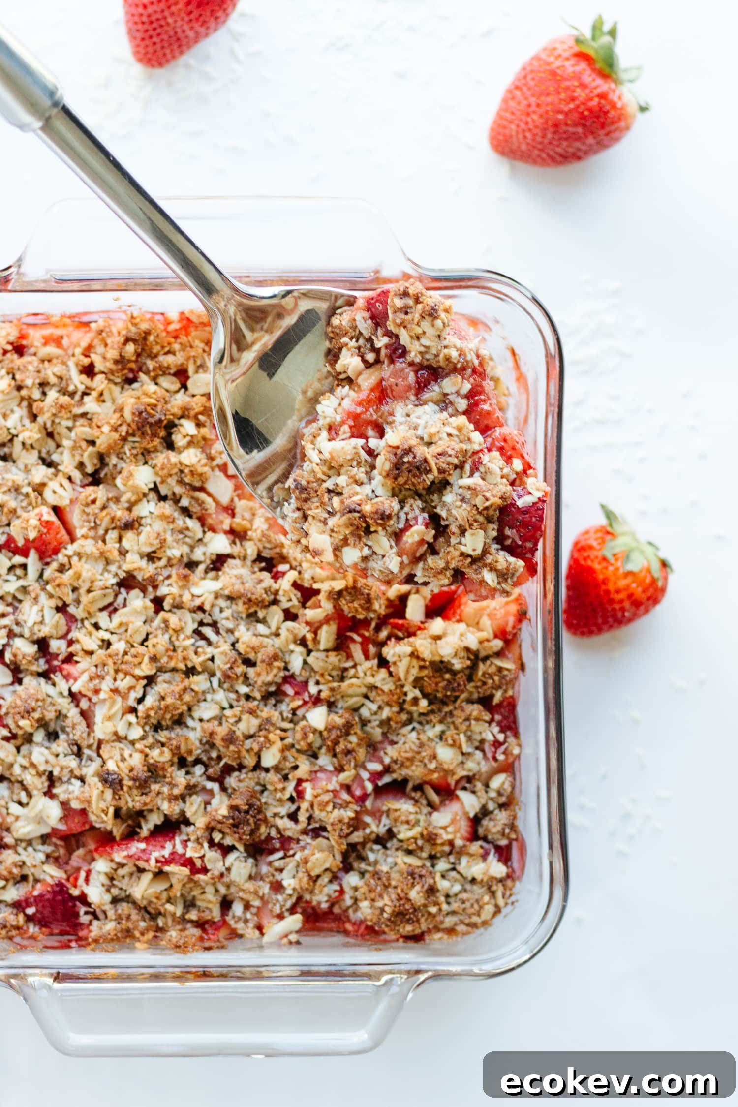 Strawberry Coconut Crisp being scooped out of baking dish