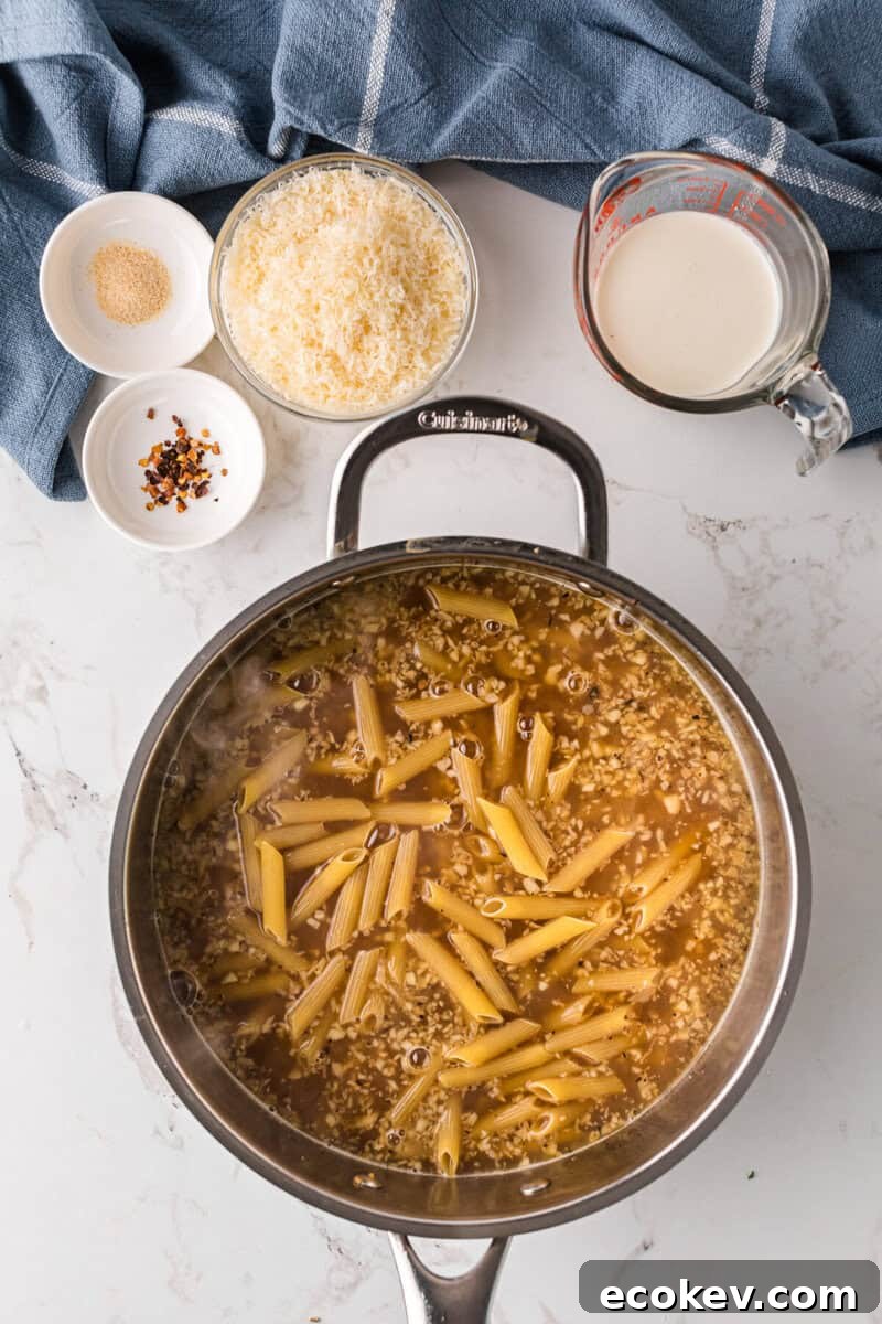 cooking the pasta in the chicken broth.