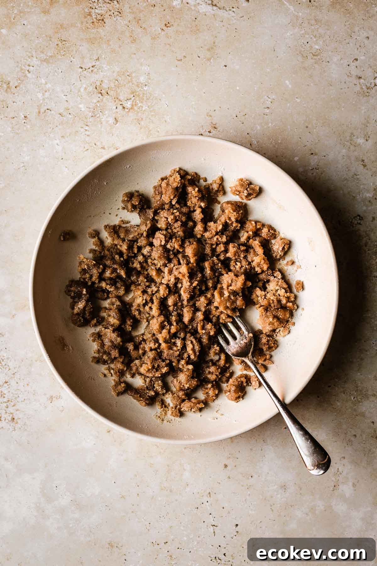 A shallow tan bowl with streusel topping.