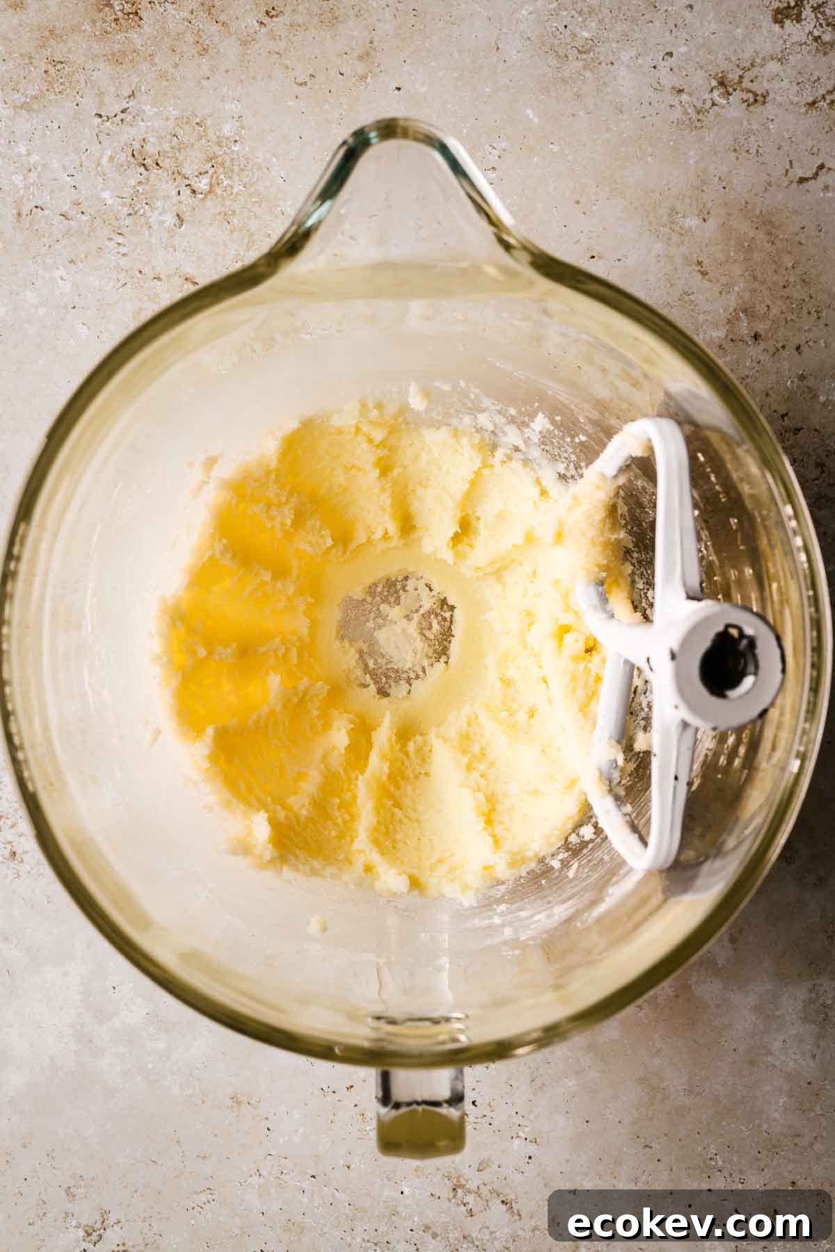A mixing bowl with creamed butter and sugar.