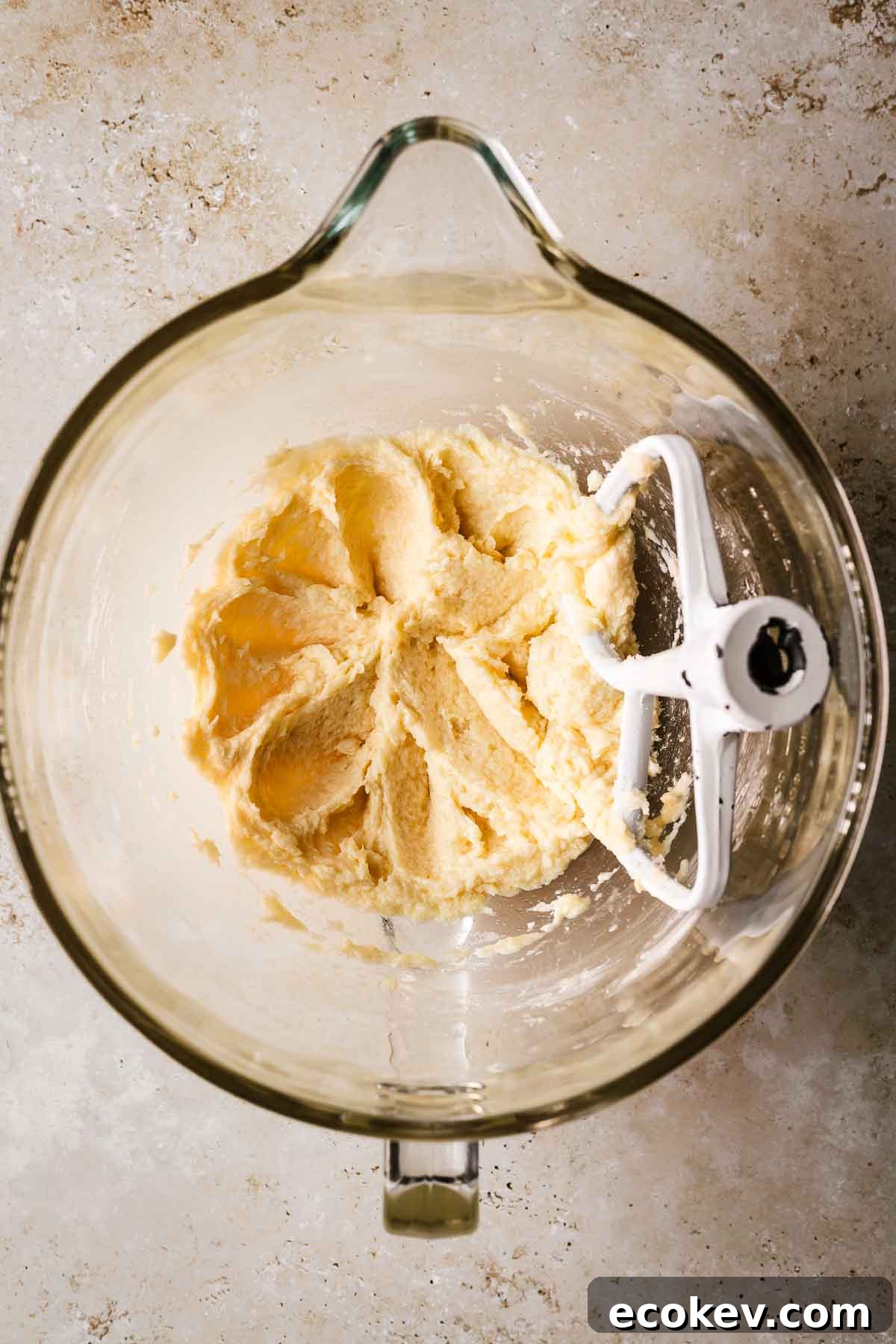 A mixing bowl with creamed butter and sugar with egg and vanilla added.