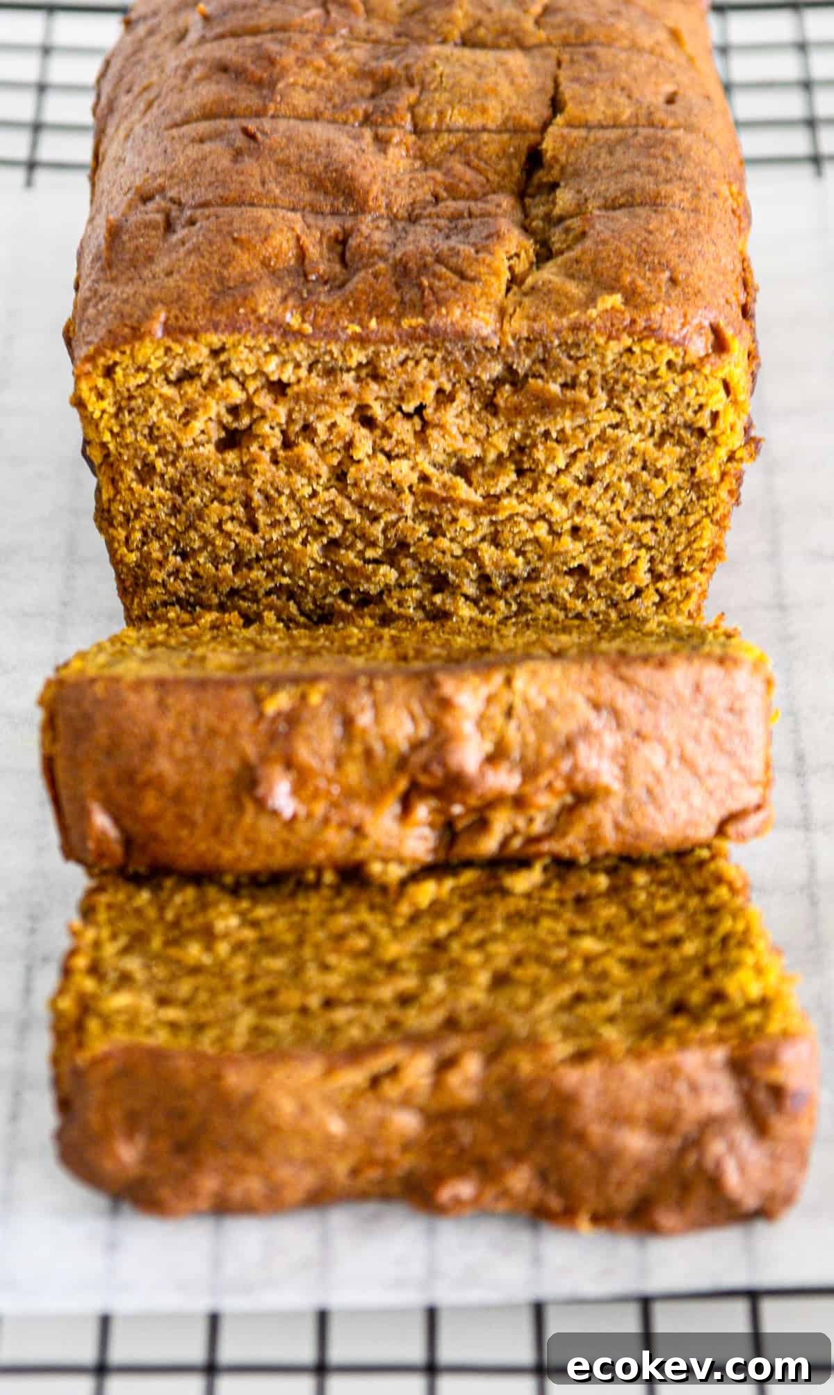 A gluten free pumpkin loaf with two slices cut from it.