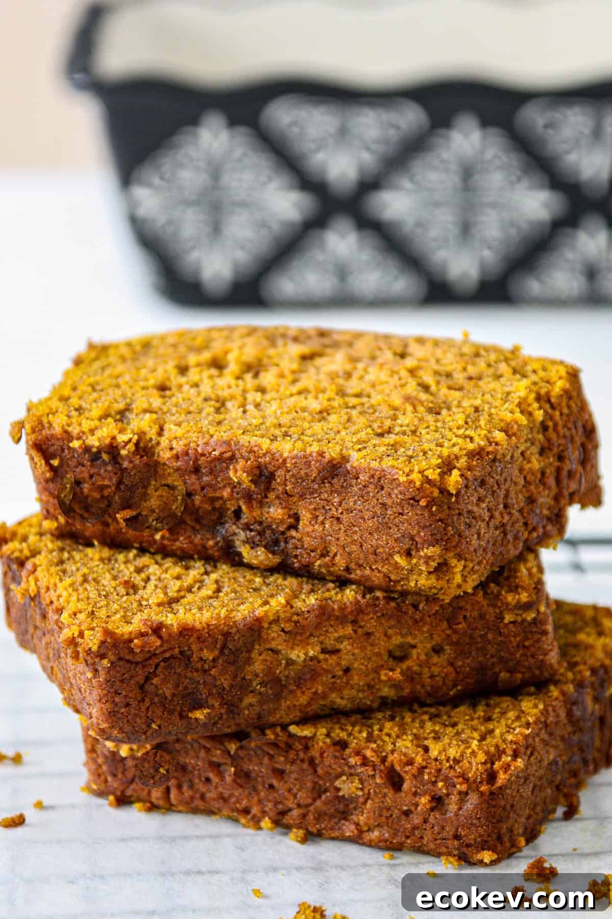 A stack of three slices of gluten free pumpkin bread.