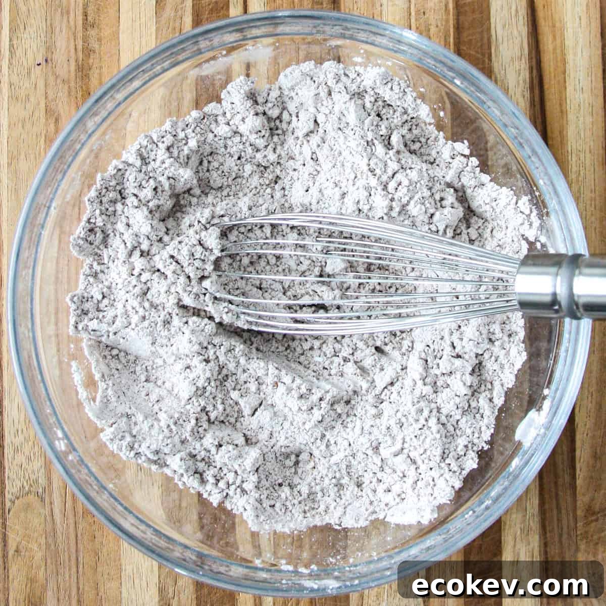 The flour, spices, baking soda, salt and baking powder in a glass bowl with a whisk.