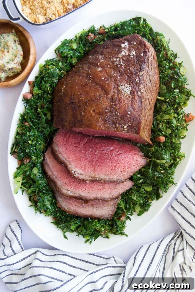 a half-sliced Picanha Roast on top of sauteed greens surrounded by other side dishes before serving