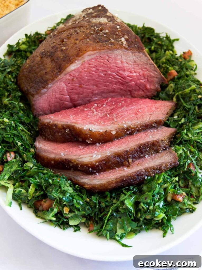 close up of a sliced Picanha Roast on sauteed greens