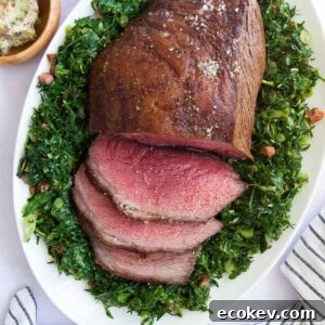 a half-sliced Picanha Roast on top of sauteed greens surrounded by other side dishes before serving