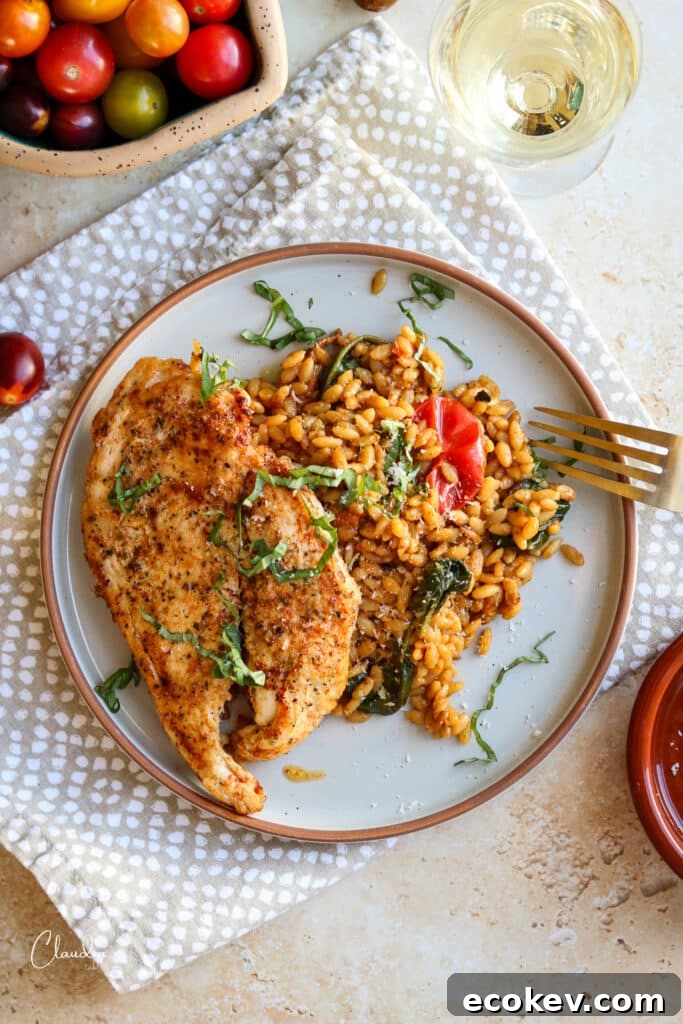 delicious chicken cutlets with creamy tomato orzo on beige plate 