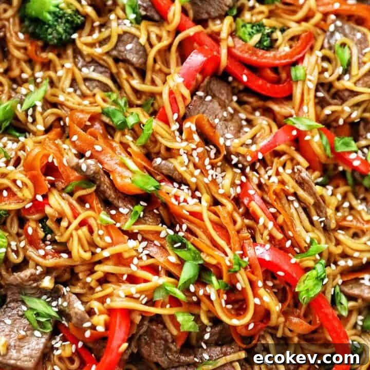 sesame garlic noodles with steak, red bell peppers, broccoli, and carrots.