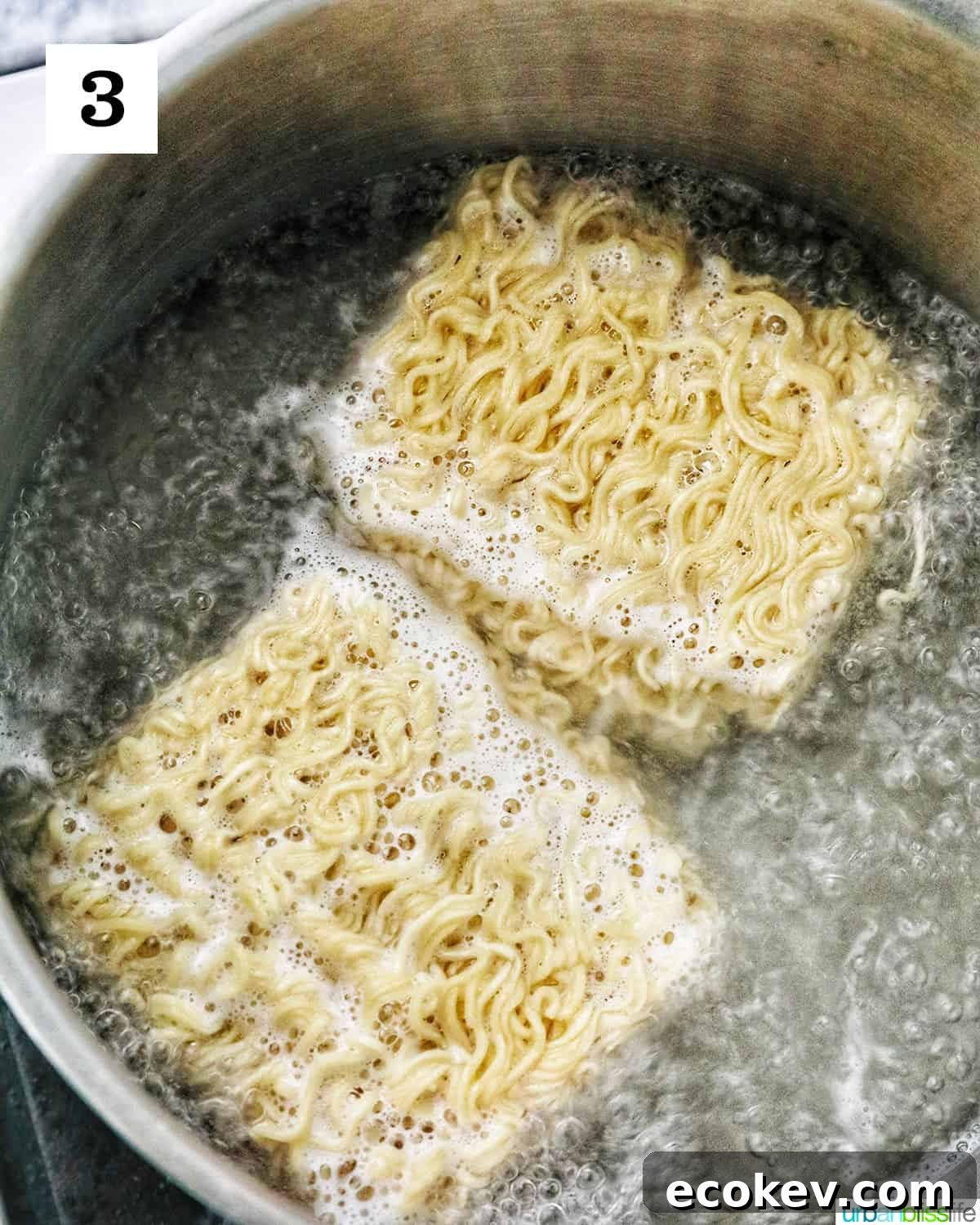 two packages of ramen noodles cooking in a large pot of boiling water.