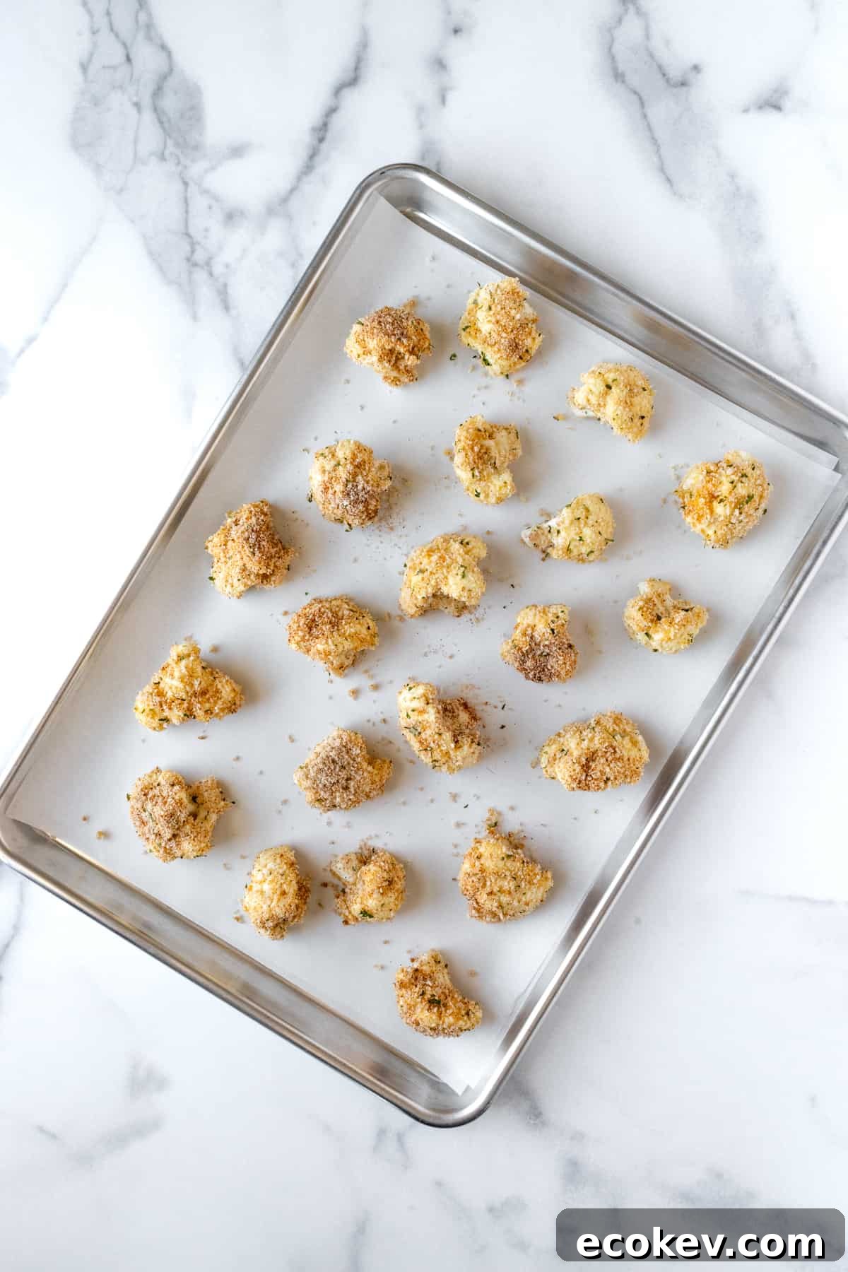 Breaded Crispy Cauliflower Bites on a parchment lined baking sheet.