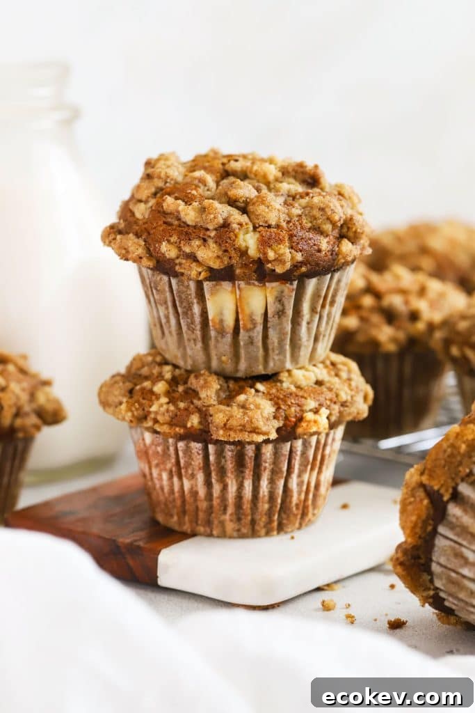 Two pumpkin cream cheese muffins stacked next to a bottle of milk