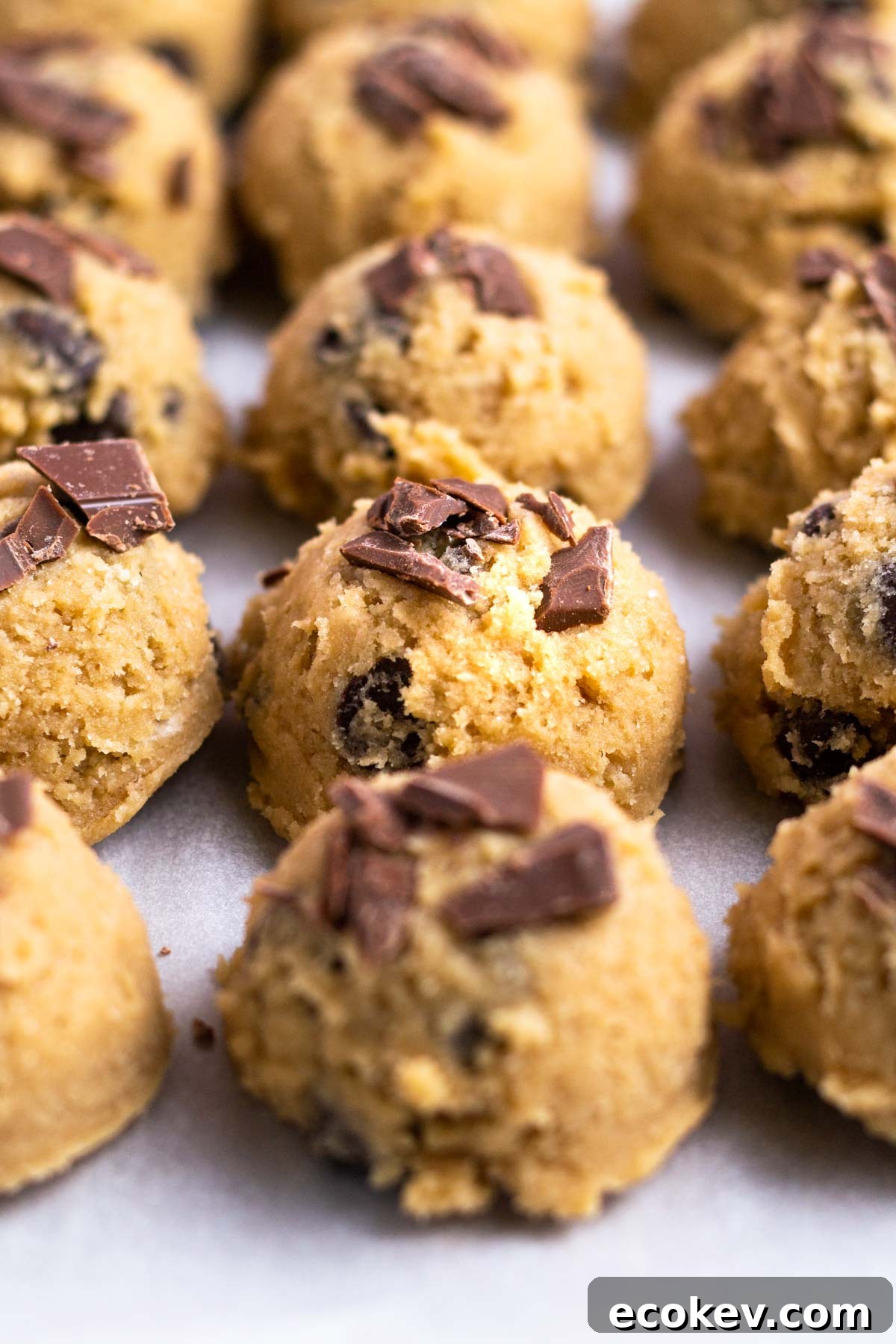 cookie dough balls on a parchment lined baking sheet