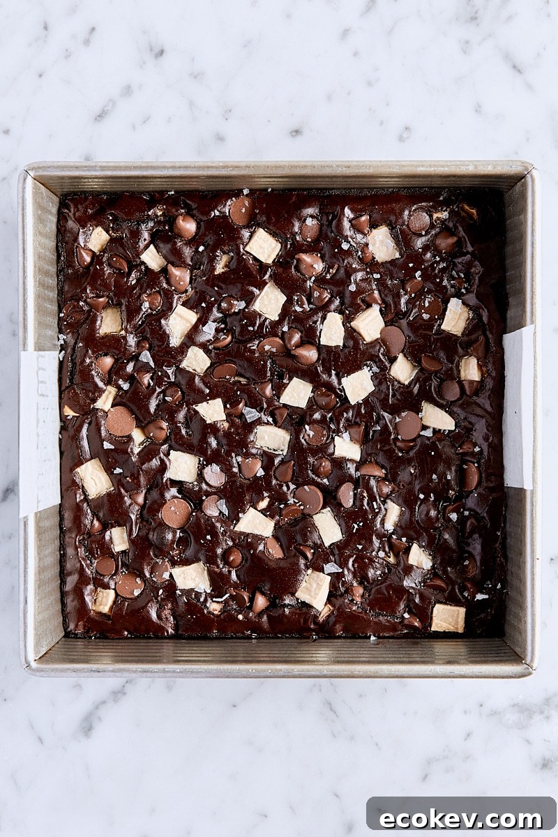 Baked triple chocolate brownies in parchment-lined pan