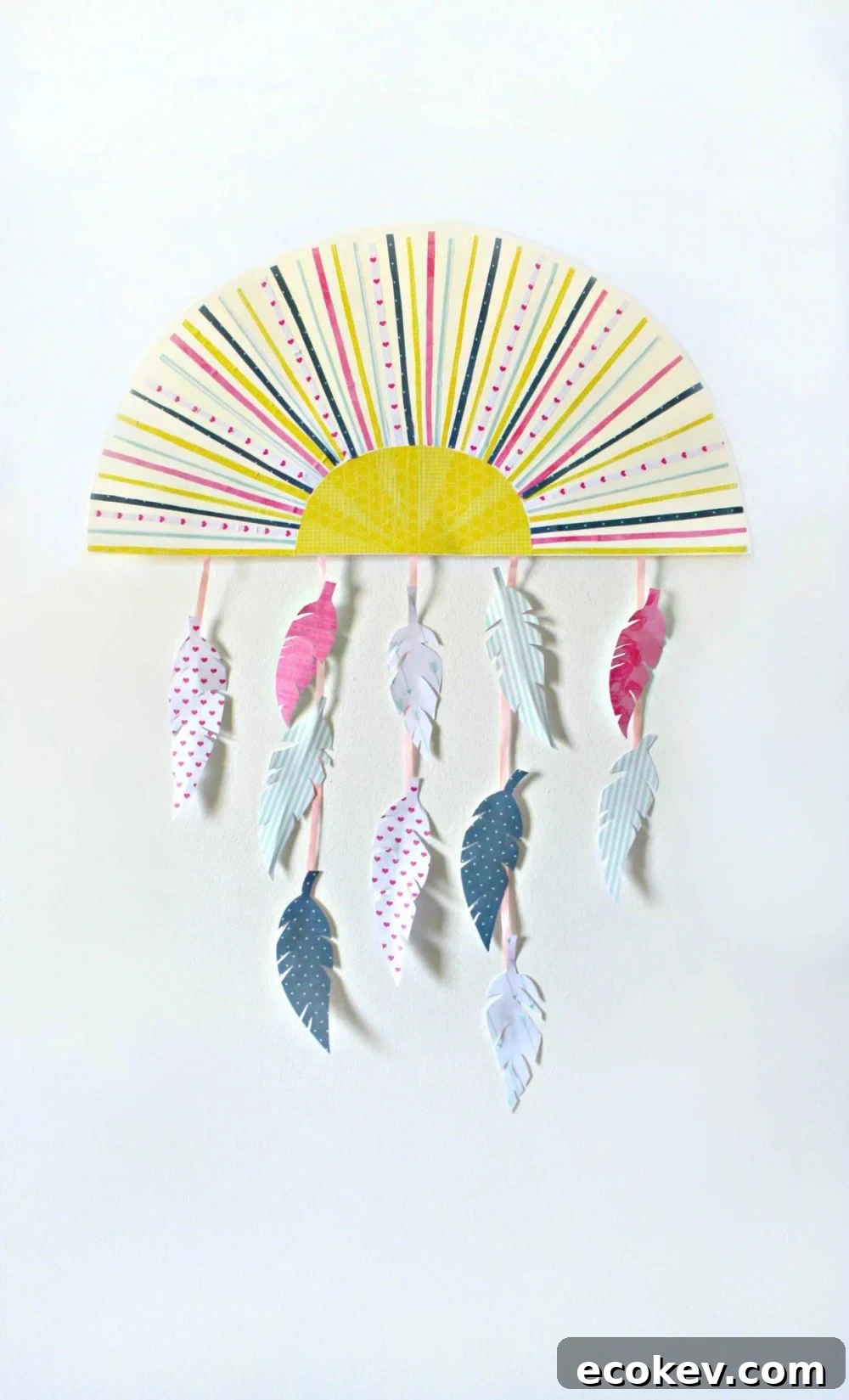 Feather wall decor in the shape of a half sun with hanging feathers