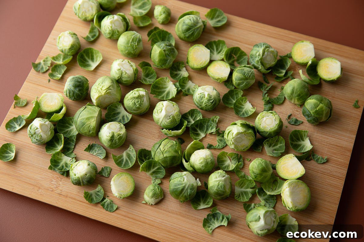 trimmed halved brussels sprouts on a wooden cutting board