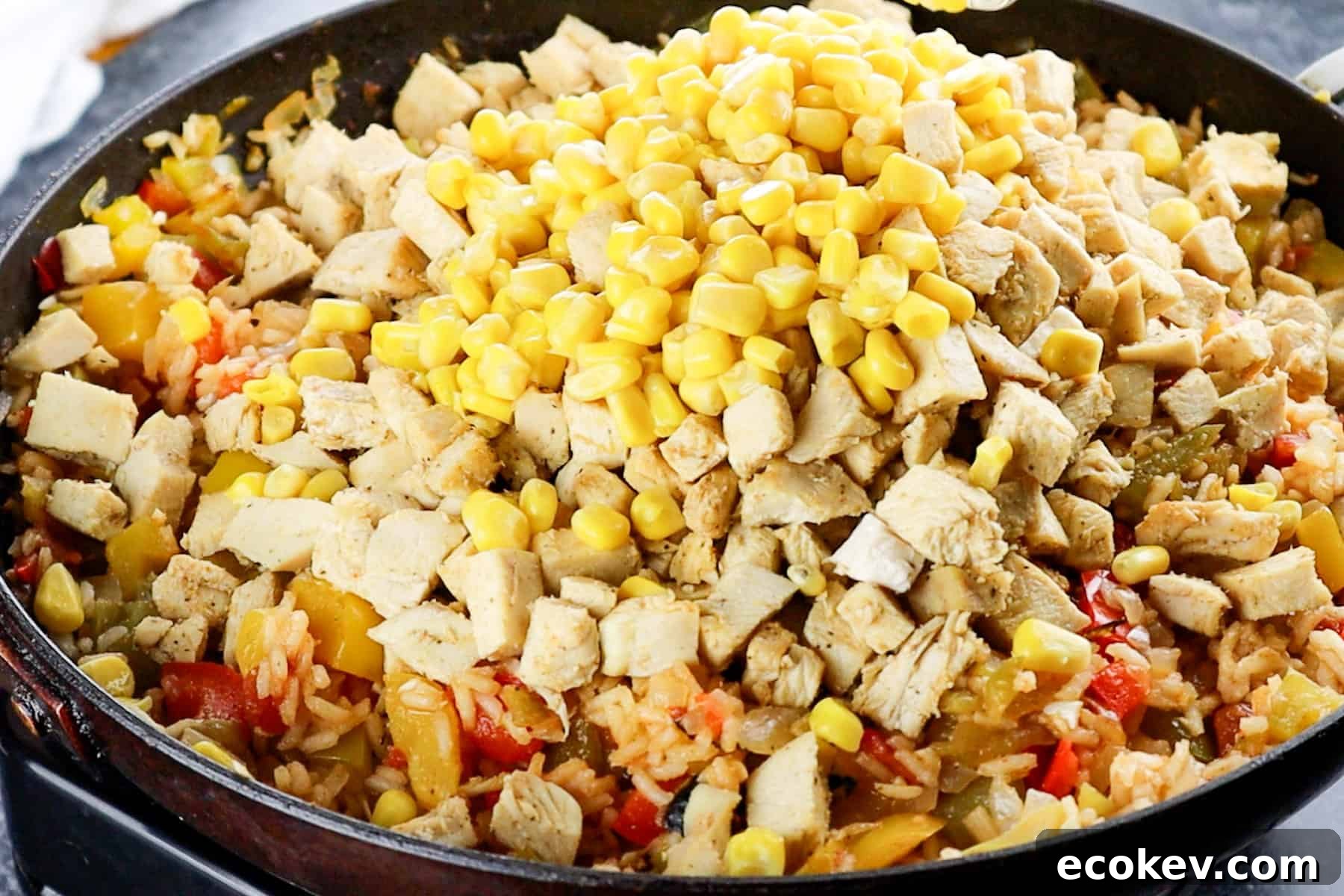 adding corn and chicken to skillet
