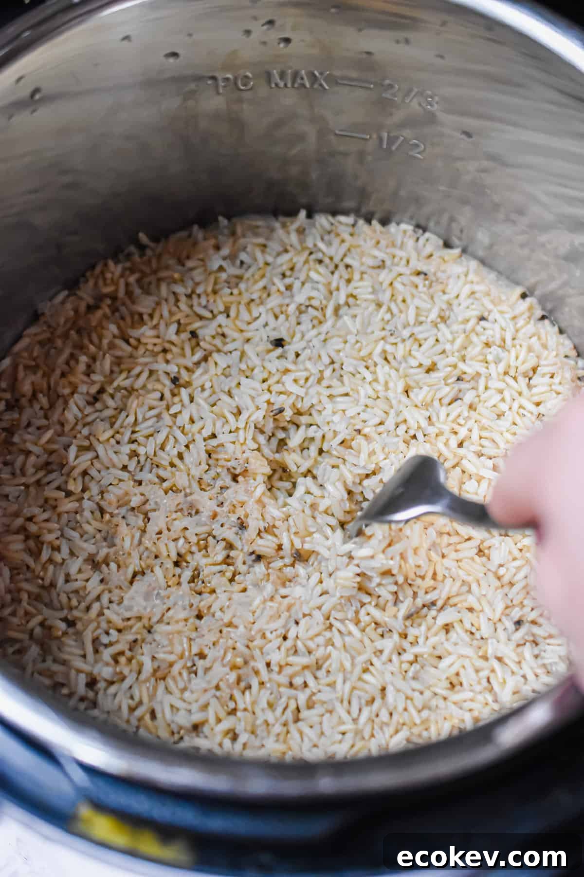 A rice is fluffing the brown rice in the Instant Pot.